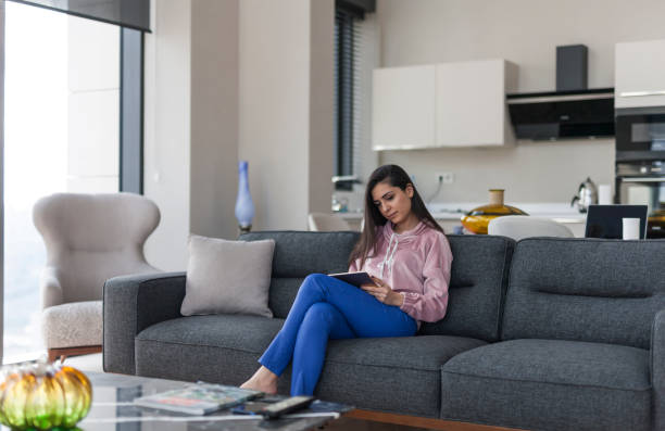 istock Young women surfing internet on digital tablet at home 1130976146