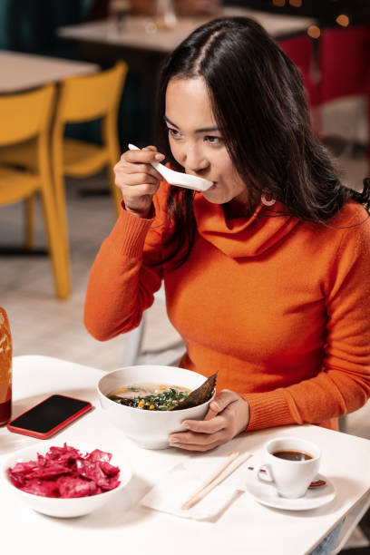 istock For the girl its more convenient having the ordered dinner with a spoon, not chopsticks. 1130977840
