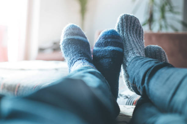 집에서 겨울에 편안 하 게 쉴: 털이 있는 커플 양말이 소파에 누워 있습니다. - sofa couple relaxation comfortable 뉴스 사진 이미지