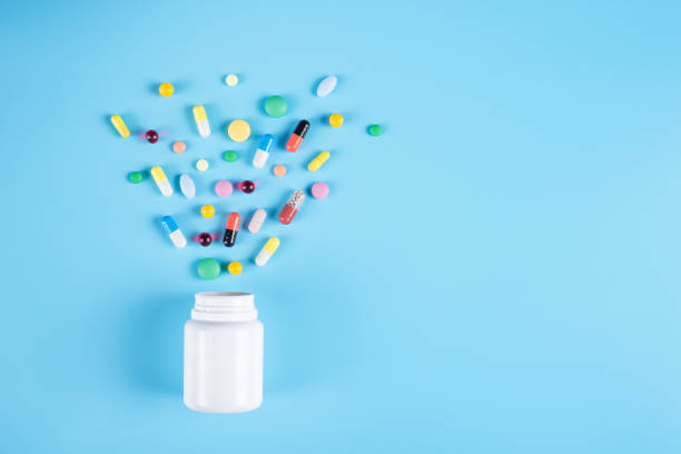 様々な医薬品の丸薬、タブレット、青の背景に白い瓶。テキスト用のスペースのコピー - capsule pill white nutritional supplement ストックフォトと画像