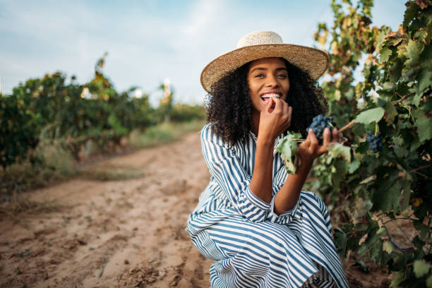 istock Young black woman eating a grape in a vineyard 1130982781