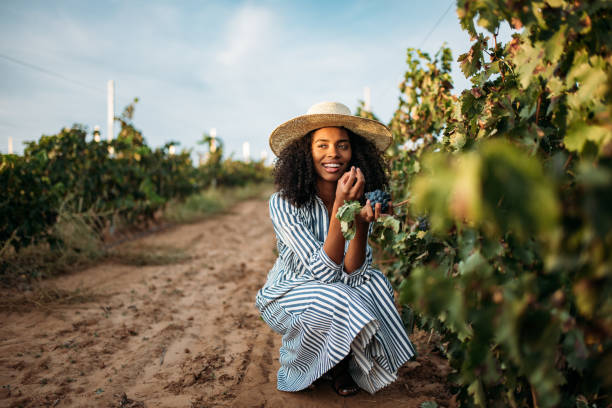 istock Young black woman eating a grape in a vineyard 1130982787