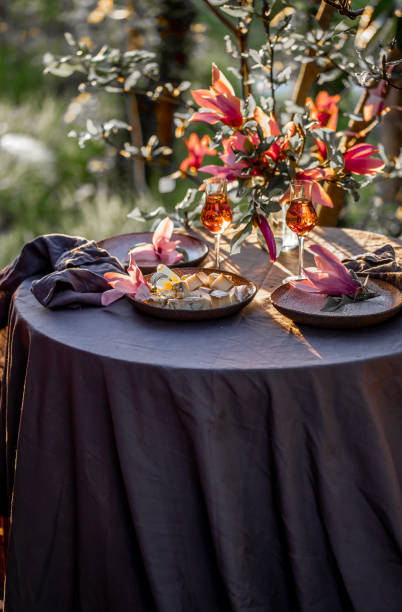 istock Beautiful table setting in garden on sunset light. Table decorated with magnolia flowers under magnolia tree 1130982927