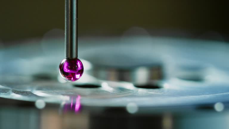 Close-Up of a Coordinate Measuring Machine Using a Ruby Red Torch Probe to Measure Tolerances of Parts in a Manufacturing Facility