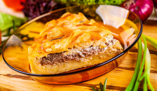 istock Meat pie with potato and onion in glass bowl 1130985499