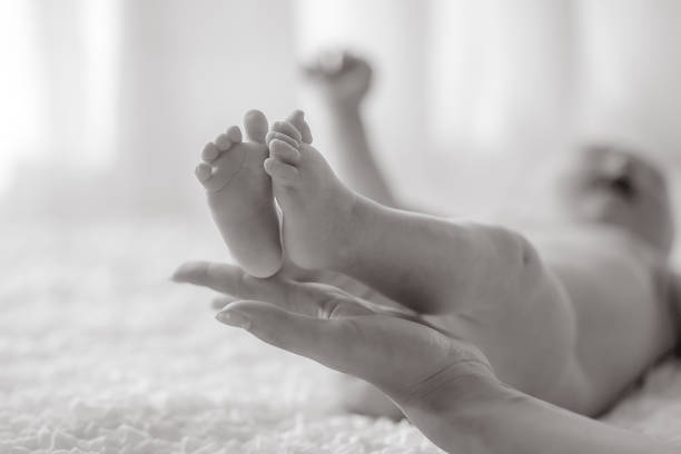 istock Baby legs in mother's hands 1130986632