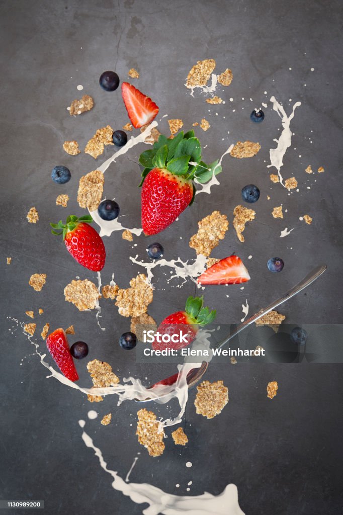 Breakfast levitation, cereal with strawberry and blueberry milk. splashes of milk Berry Stock Photo