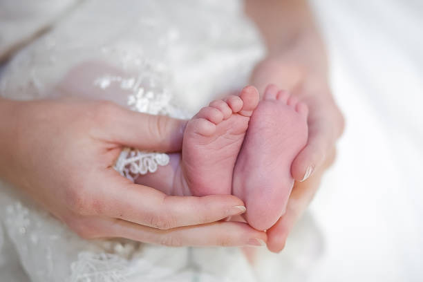istock Baby legs in mother's hands 1130989291
