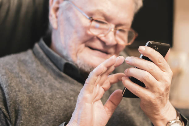 istock old senior man in glasses using mobile phone b 1130990728