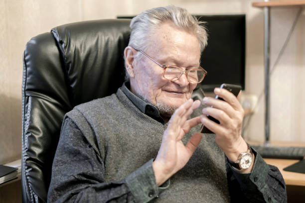 istock old senior man in glasses using mobile phone b 1130990731