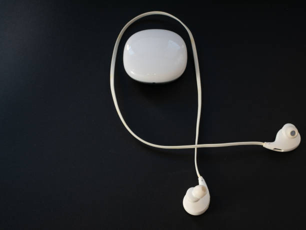istock small white wireless earbuds with plastic box on black background. portable music concept 1130992713