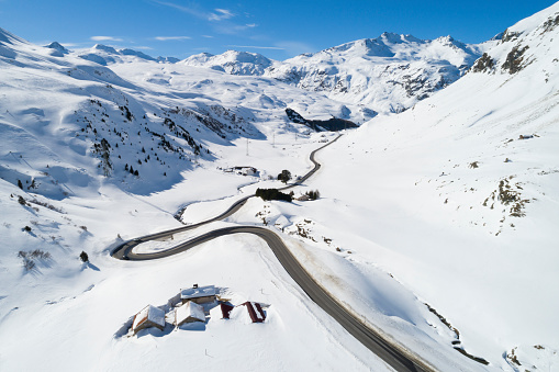 Mountain winter landsccape with winding road, aerial view, Graubunden Canton, Swiss Alps.