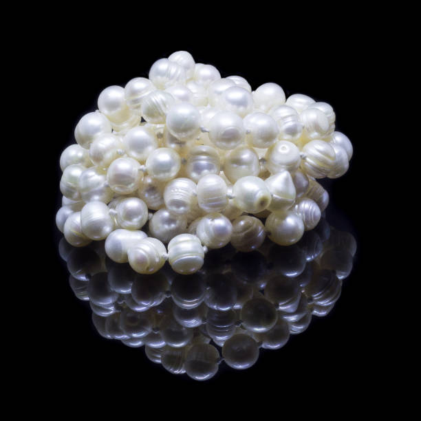 istock Natural white pearl beads on a black background 1130993821