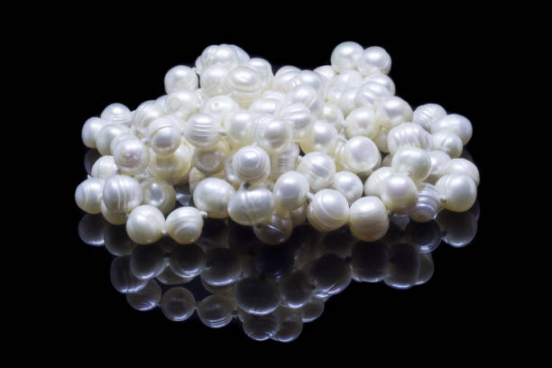 istock Natural white pearl beads on a black background 1130994374