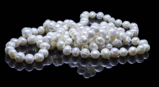 istock Natural white pearl beads on a black background 1130994484