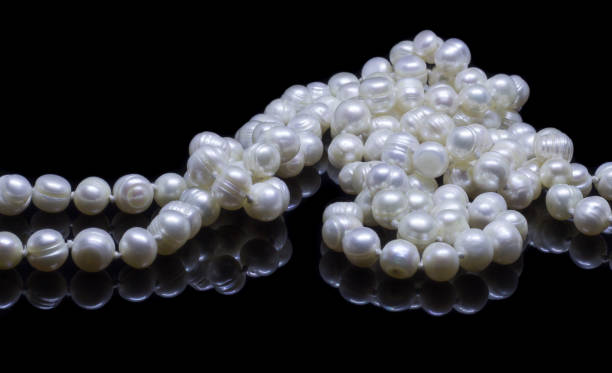 istock Natural white pearl beads on a black background 1130994487