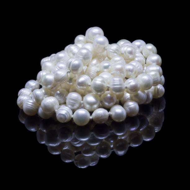 istock Natural white pearl beads on a black background 1130994491