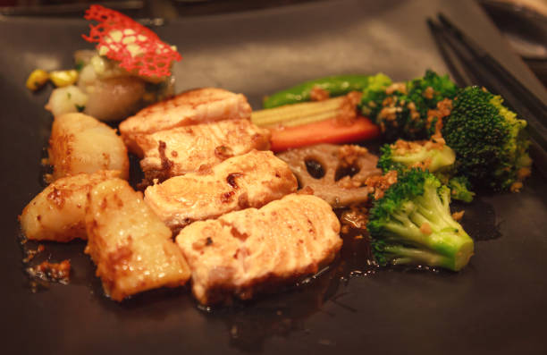 fresh assorted seafood, salmon fillet, scallop and vegetable teppanyaki grill (japanese cuisine that uses an iron griddle or hot fry pan to cook food) in traditional steakhouse. food cooking concept - teppan yaki imagens e fotografias de stock