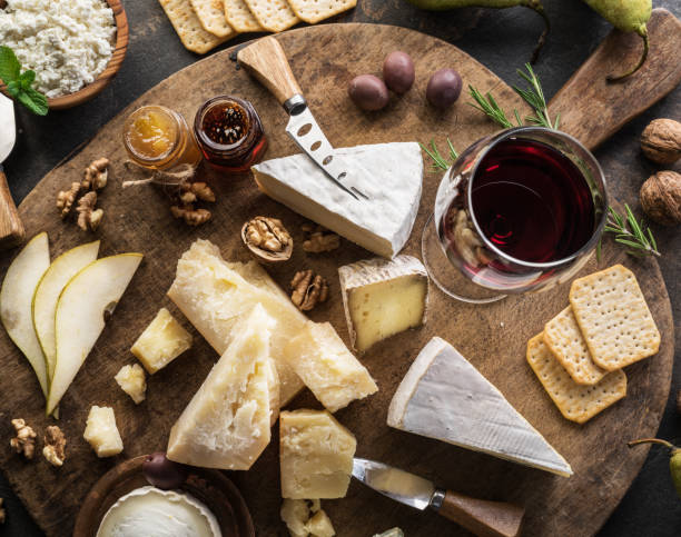 istock Cheese platter with different cheeses, fruits, nuts and wine on stone background. 1130994911