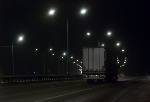 truck moves at night on the highway in winter