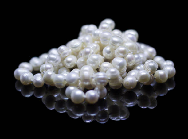 istock Natural white pearl beads on a black background 1130996433