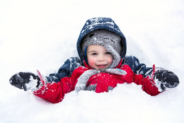 Young Boy Partially Covered in Snow stock photo