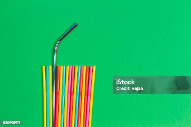 Stainless Steel Reusable Drinking Straw With Plastic Straws On Green Background Stock Photo - Download Image Now