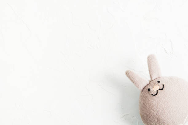 istock Funny textile rabbit on white stone background in right corner 1130999257