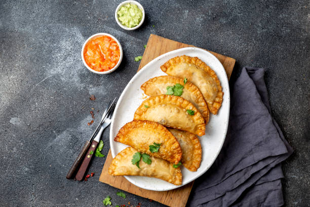 istock Latin American fried empanadas with tomato and avocado sauces. Top view 1130999655