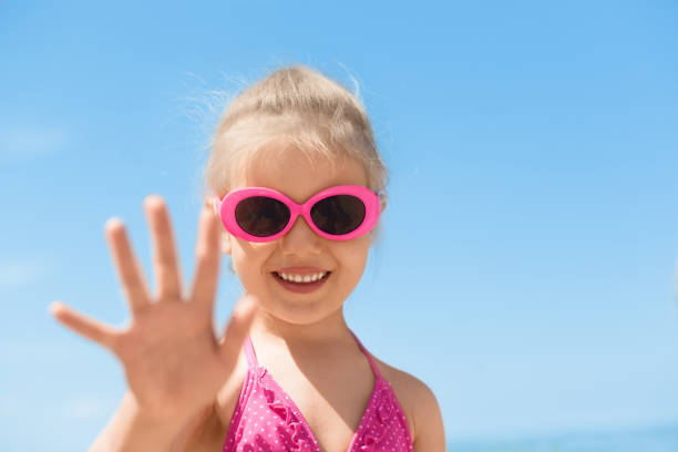 istock child beach waving hand summer camp 1131002554