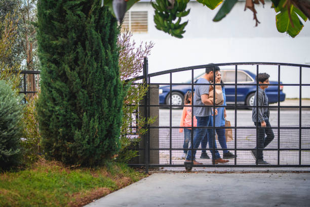 Family coming home after grocery shopping Family coming home from grocery shopping. Parents and children are arriving in front yard. They are spending time together during weekend. walking into glass door stock pictures, royalty-free photos & images