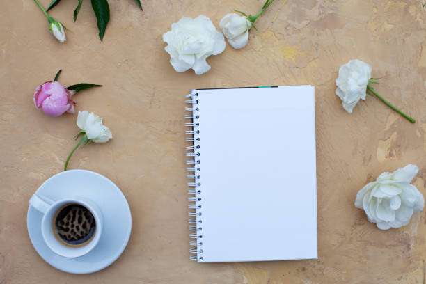 istock Open notebook with flowers and black coffee on beige background. Flat lay. Top view. Copy space. 1131004017