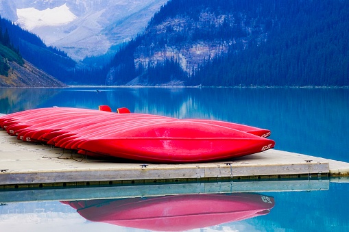 red canoes lined up on dock at Lake Louise with mountain background