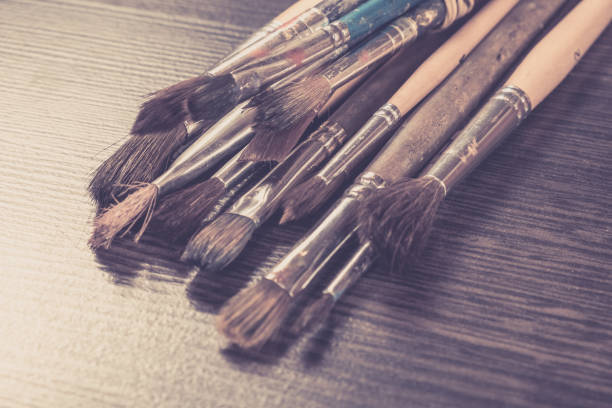 istock Artist paint brushes on wooden background, craft art process 1131010006