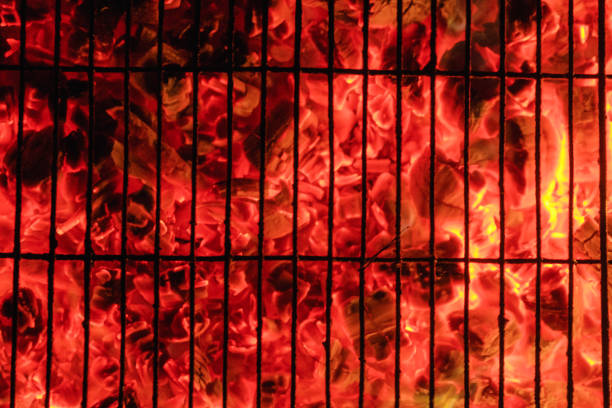 Burning and glowing charcoal with open hot flame and smoke close up