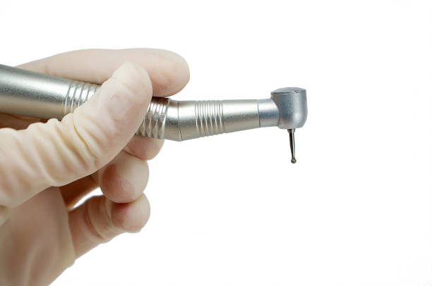 manipolo dentale nelle mani del dentista isolato su sfondo bianco primo piano, trapano dentale, bava - dental drill foto e immagini stock