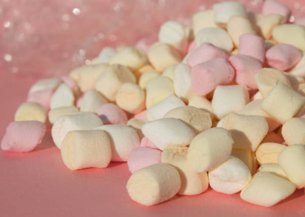 marshmallows no fundo cor-de-rosa com copyspace. configuração lisa ou vista superior com o boke no fundo. - unhealthy eating copy space marshmallow softness - fotografias e filmes do acervo