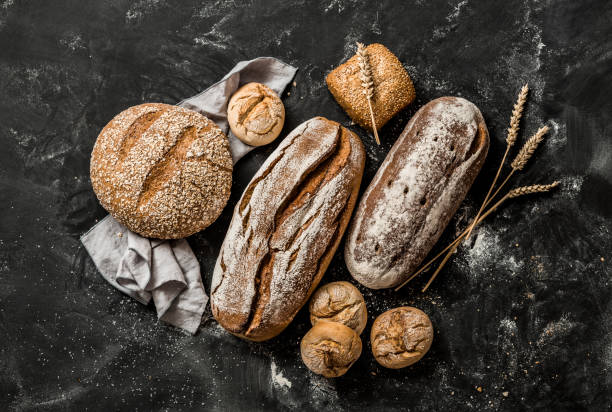 Bakery - rustic crusty loaves of bread and buns on black