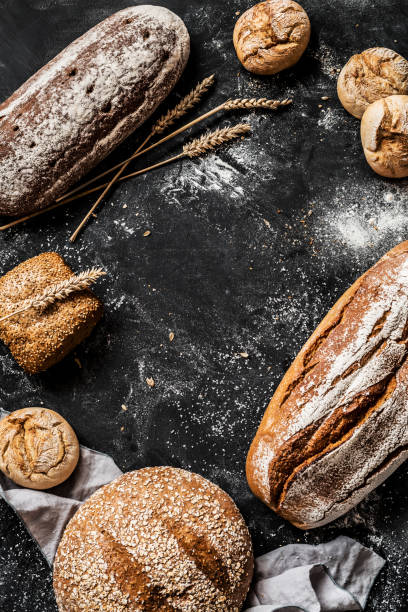 istock Bakery - rustic crusty loaves of bread and buns on black 1131012167