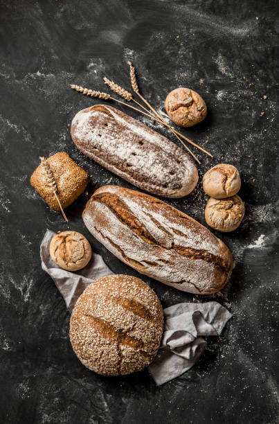istock Bakery - rustic crusty loaves of bread and buns on black 1131012168