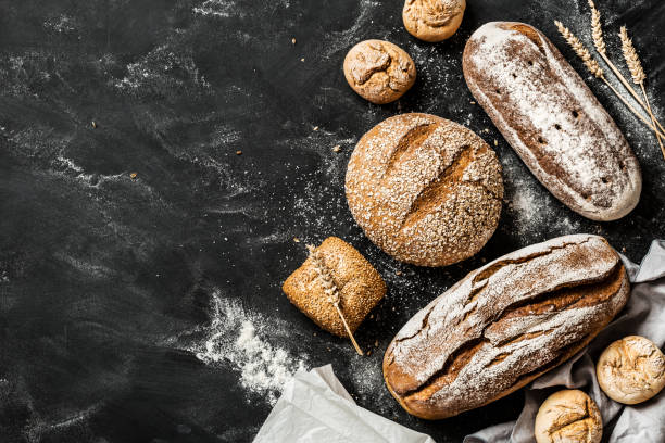 istock Bakery - rustic crusty loaves of bread and buns on black 1131012171