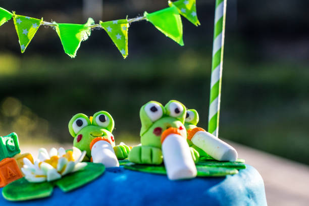 istock A blue birthday cake with green frogs figures 1131013228