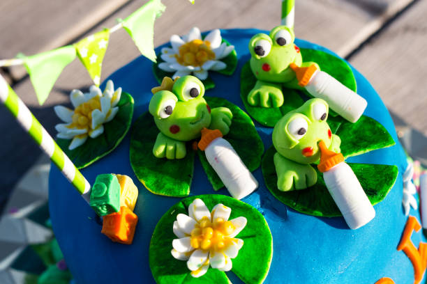 istock A blue birthday cake with green frogs figures 1131013232