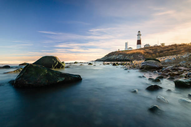 Lighthouse beacon sitting on a cliff overlooking the ocean during sunset. Montauk State Park, New York Long Island New York montauk point stock pictures, royalty-free photos & images