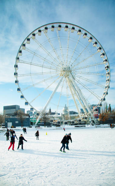 Montreal Canada people skating under the Ferris Wheel in old port quarter Montreal Canada people skating under the Ferris Wheel in old port quarter on a Sunny Christmas day place jacques cartier stock pictures, royalty-free photos & images