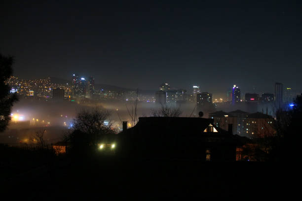towering symbol of urban energy, where electricity stays on long after dark in a fog-covered metropolis. Modern architecture defined by light and power, standing as a beacon of electricity in a dark, hazy sky.