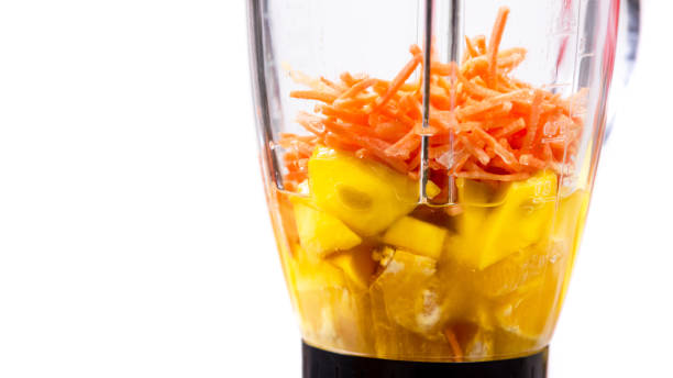 istock mango, orange and carrot smoothie ingredients in the blender 1131020716