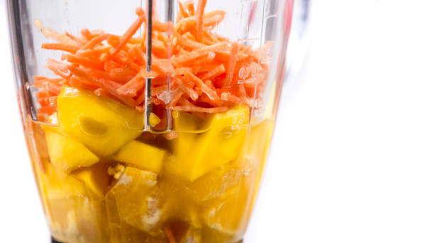 istock mango, orange and carrot smoothie ingredients in the blender 1131020741