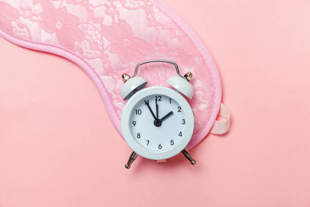 istock Sleeping mask and alarm clock on pink pastel background 1131026575