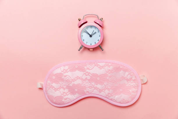 istock Sleeping mask and alarm clock on pink pastel background 1131026639